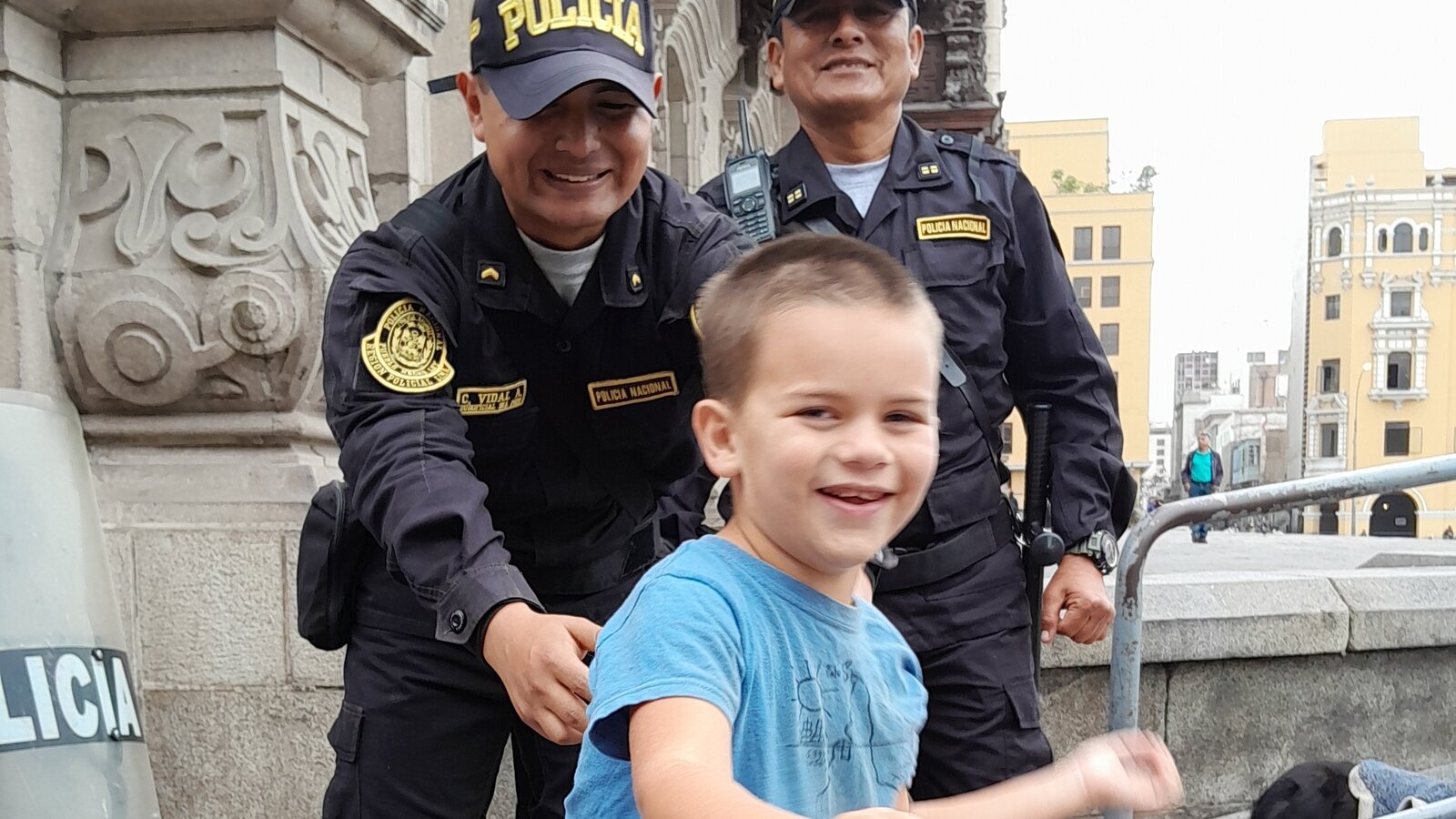 Sam smiling near two police officers in Lima, Peru.