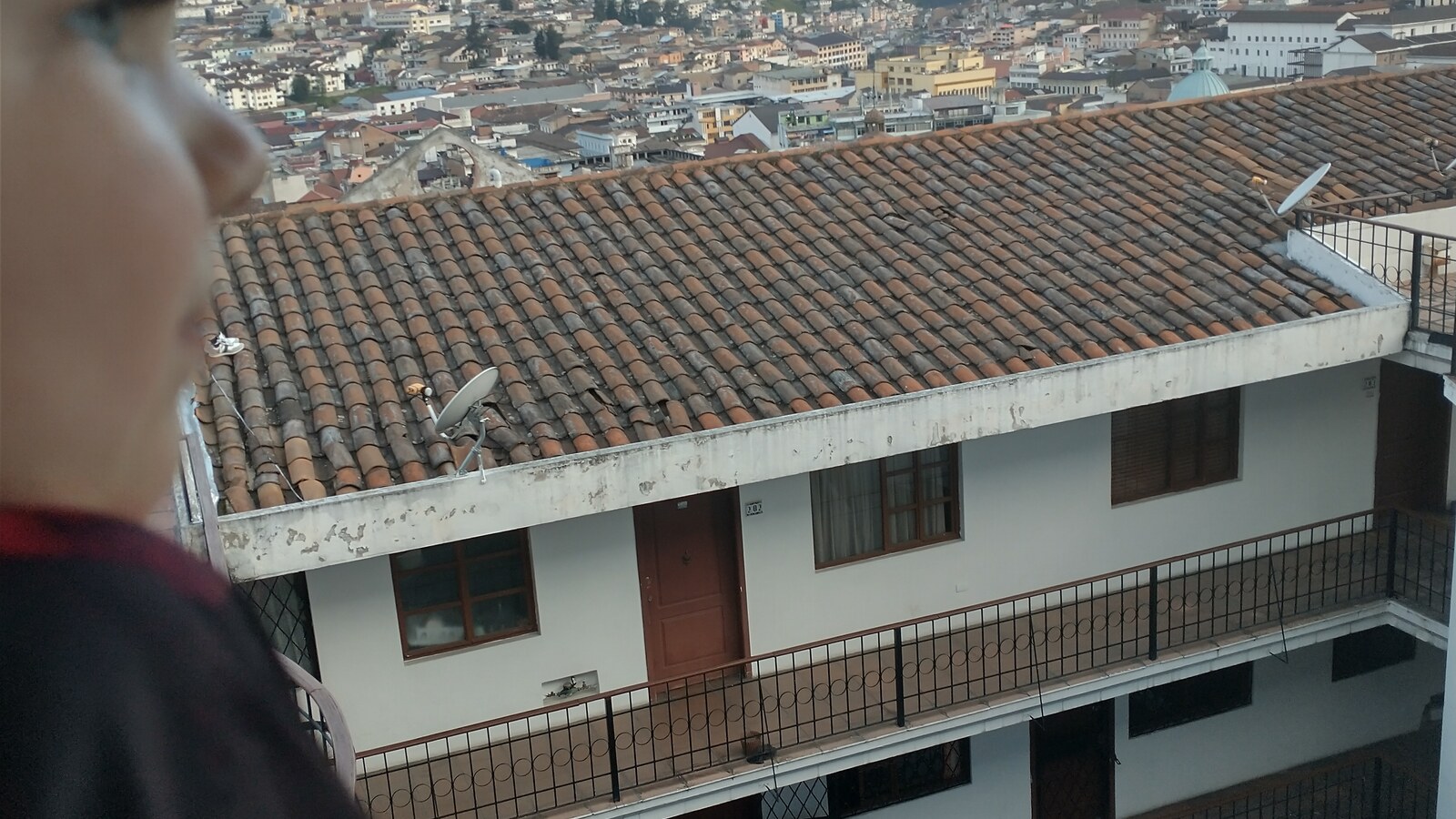 Sam standing at an overlook above the homes and streets of Quito, Ecuador.