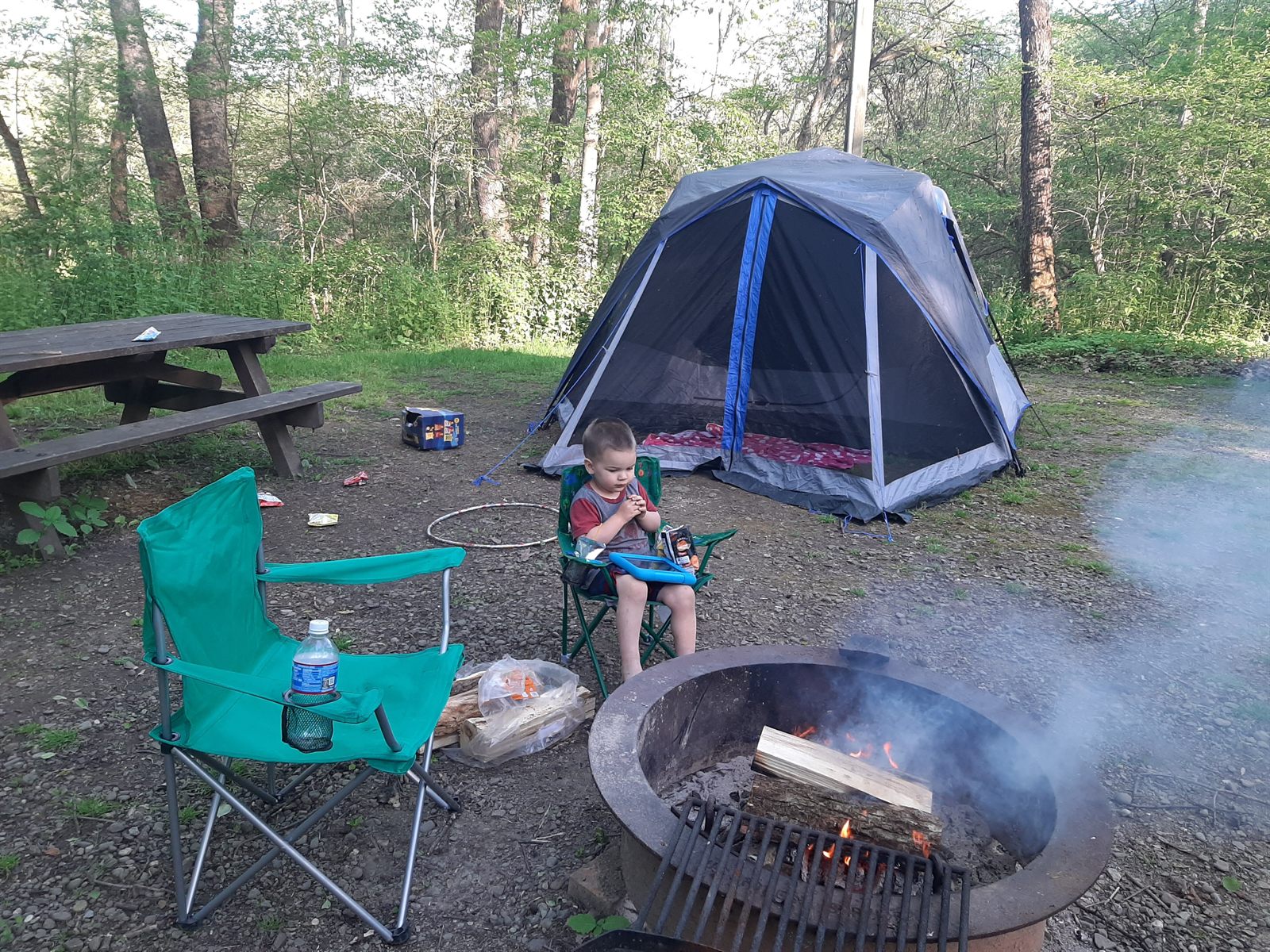 Sam sitting at a family campsite, illustrating the need for an adult home that supports ordinary life, activity, and belonging.