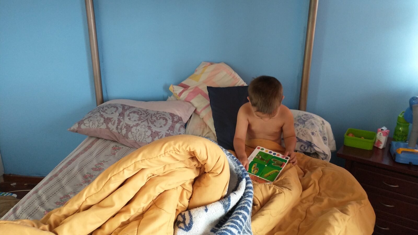 Sam sits in bed looking at a picture book in the townhouse where his family lived for six months in historic Quito, Ecuador.