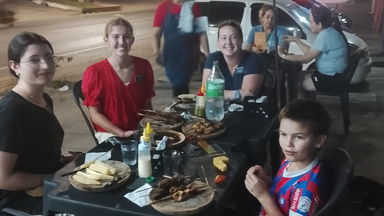 Sam shares an outdoor evening meal with friends and missionaries from The Church of Jesus Christ of Latter-day Saints.